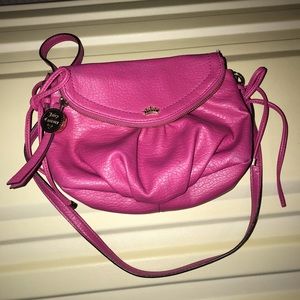 Small dark pink crossbody with black trim on strap